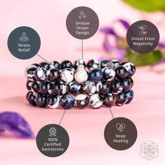 Exotic Orca Agate Bracelet of Deep Healing displayed with flowers on a natural stone background.